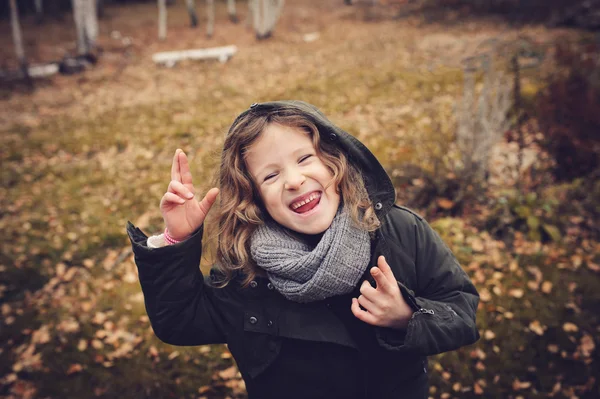 Niño feliz jugando con hojas en otoño — Foto de Stock