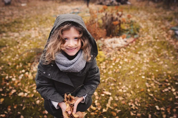 Criança feliz brincando com folhas no outono — Fotografia de Stock