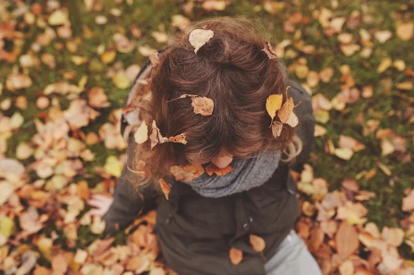 Счастливый ребенок, играющий с листьями осенью — стоковое фото