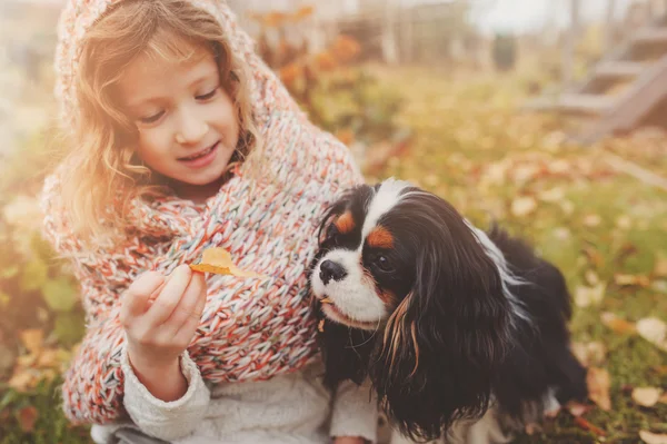 Kız çocuk cavalier king charles spaniel köpeği ile rahatlatıcı — Stok fotoğraf