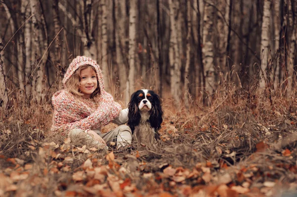 Barn tjej avkopplande med hennes cavalier king charles spaniel hund — Stockfoto