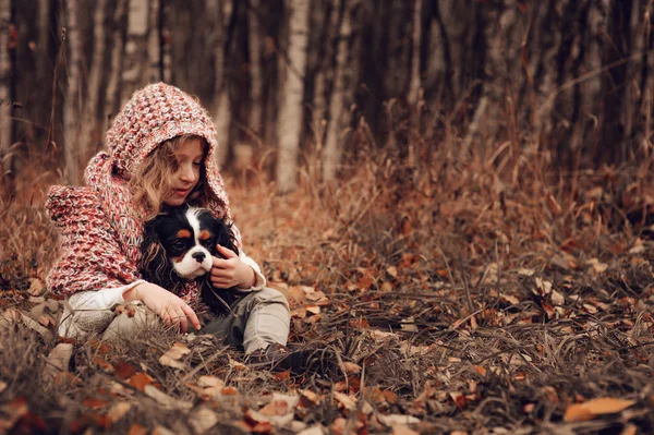 Kız çocuk cavalier king charles spaniel köpeği ile rahatlatıcı — Stok fotoğraf