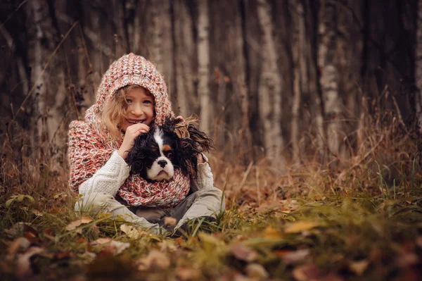 Barn tjej avkopplande med hennes cavalier king charles spaniel hund — Stockfoto