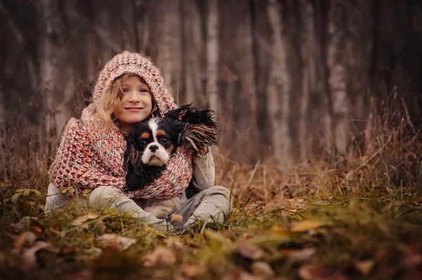 Kız çocuk cavalier king charles spaniel köpeği ile rahatlatıcı — Stok fotoğraf