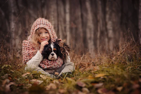 Barn tjej avkopplande med hennes cavalier king charles spaniel hund — Stockfoto