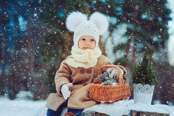 Aranyos baba lány élvezi téli séta a havas park, meleg kalapot és kabátot visel — Stock Fotó