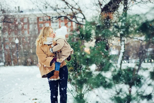 Счастливая мама с маленькой дочкой гуляют в заснеженном зимнем парке. Рождество семейное время . — стоковое фото
