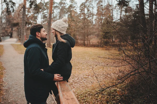 Amando jovem casal feliz juntos ao ar livre em acolhedor passeio quente na floresta de outono — Fotografia de Stock