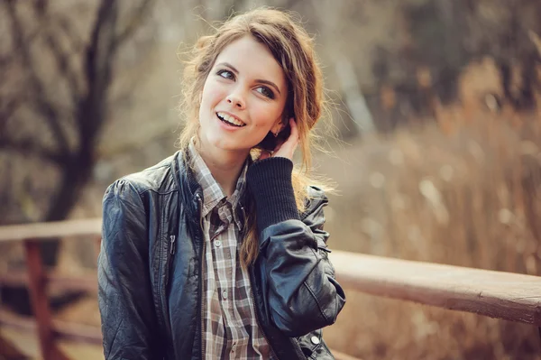 Outono ao ar livre retrato de jovem mulher bonita com maquiagem natural em jaqueta de couro e camisa xadrez, vintage macio tonificado — Fotografia de Stock