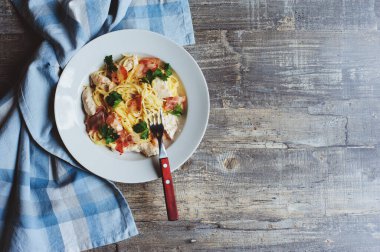 Pişmiş krem peynirli makarna, kızarmış tavuk ve domuz pastırması bir kişiye servis edilir.