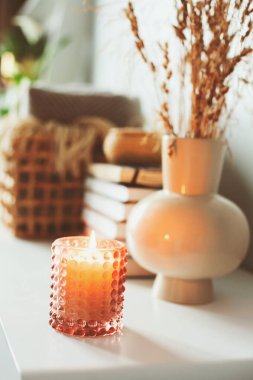 Yumuşak sazlıklar, mumlar ve bej renkli kitaplarla dolu samimi modern iç mekan detayları. Minimalist İskandinav Tasarım Evi.