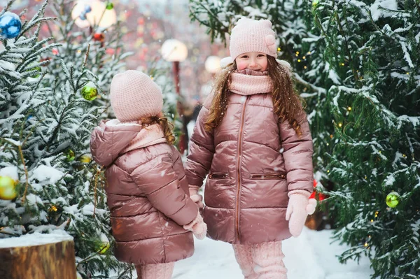 겨울철 눈내리는 도시에서 야외에서 자매들의 크리스마스 크리스마스 휴가를 밖에서 보내고 — 스톡 사진