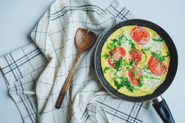 Lezzetli İtalyan usulü vejetaryen kahvaltısı. Mozarella peynirli omlet, roka ve domates.