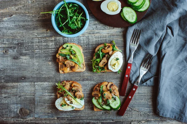 Varias Tostadas Vegetarianas Por Mañana Con Champiñones Aguacate Rúcula Pepino Fotos De Stock