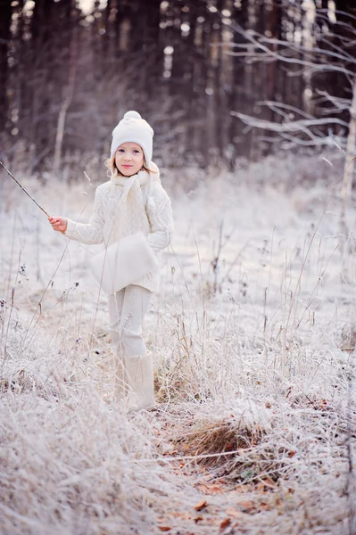 Cute happy child girl walking in snowy winter forest — Stock Photo, Image