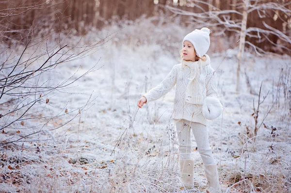 Cute happy child girl walking in snowy winter forest — Stock Photo, Image