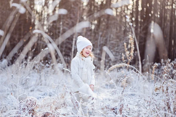 Cute happy child girl walking in snowy winter forest — Stock Photo, Image