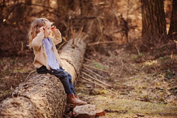 Schattig gelukkig blond kind meisje in gebreide trui en blauw shirt wandelen in vroege voorjaar woud — Stockfoto