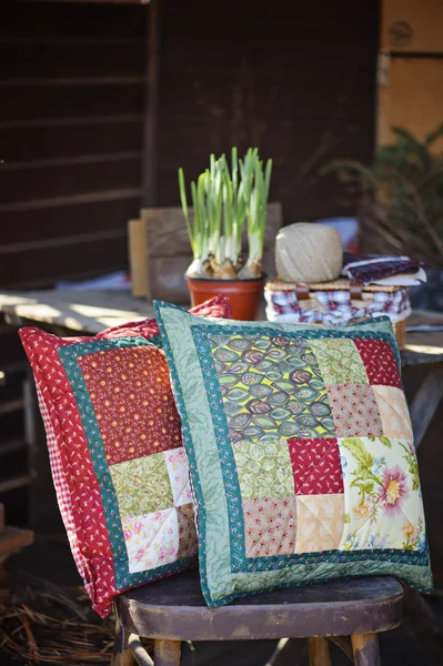 Almofadas de retalhos artesanais com bulbos de narciso de primavera e galho na mesa de madeira — Fotografia de Stock