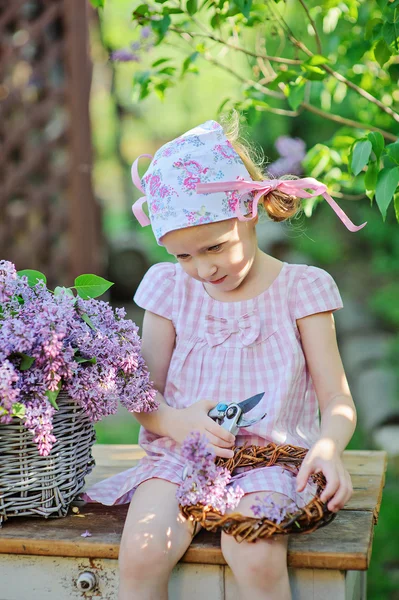 Retrato de primavera de menina adorável com cesta de lilases no jardim ensolarado primavera — Fotografia de Stock