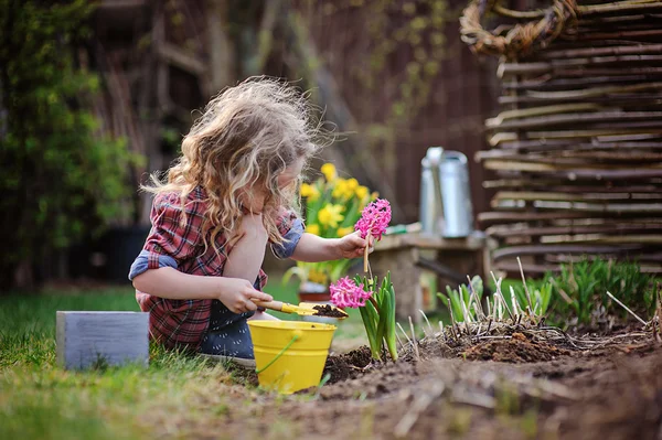 Bambino ragazza piantare fiori nel giardino primaverile — Foto Stock