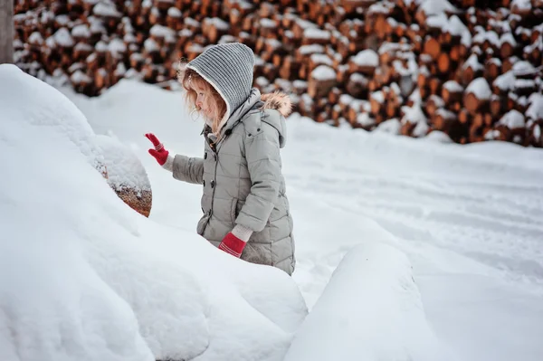 Niña jugando con la nieve en el bosque de invierno — Foto de Stock