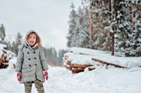 Happy funny child girl on the walk in winter snowy forest — Stock Photo, Image