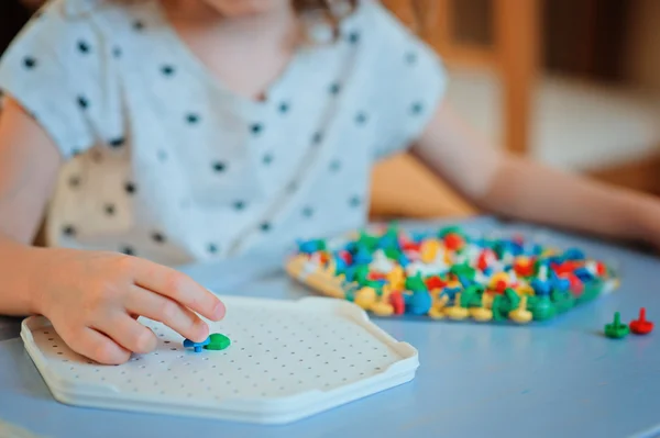 Primo piano di mani bambino gioca con mosaici a casa — Foto Stock