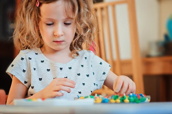 Peuter kind meisje spelen met mozaïek thuis — Stockfoto