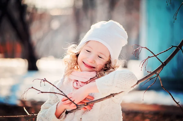 Bahar yürüyüşte ağaç dalı ile güneşli günde mutlu gülümseyen çocuk kız portresi — Stok fotoğraf