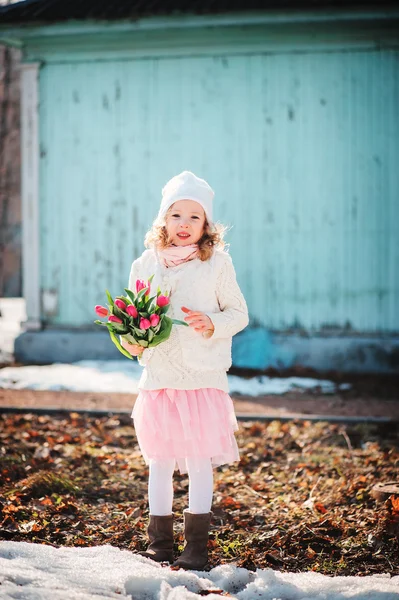 Barn tjej med tulpaner bukett på promenad i tidig vårdag — Stockfoto