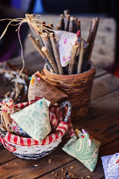 Easter decorations and fabric chicken on wooden table in country house