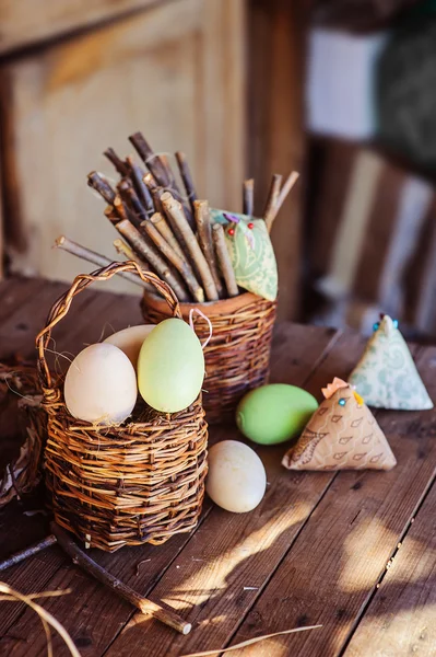 Easter eggs and fabric chicken on wooden table in country house — Stock Photo, Image