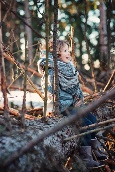 快乐的孩子的女孩坐在早春森林中有棵老松树上玩 — 图库照片