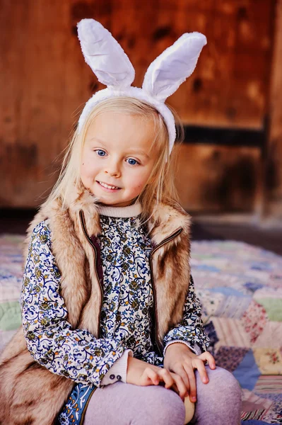 Lyckligt barnflickan bär bunny öron till påsk på trä country house — Stockfoto