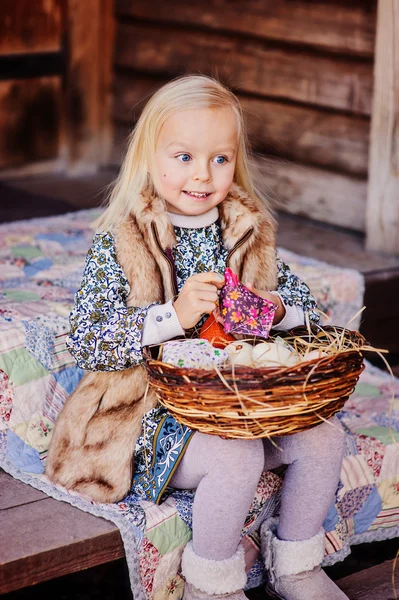 Adorable happy child girl with decorations for easter at wooden country house — Stock Photo, Image