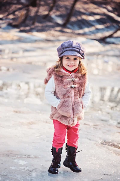 背景の上の氷の融解と早春の散歩に幸せな幼児少女の肖像画 — ストック写真