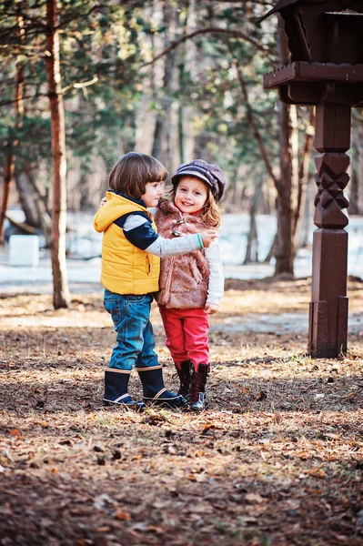 Amigos felices niños jugando juntos al aire libre en la primavera temprana caminar en el bosque. Concepto de amistad y amor . — Foto de Stock