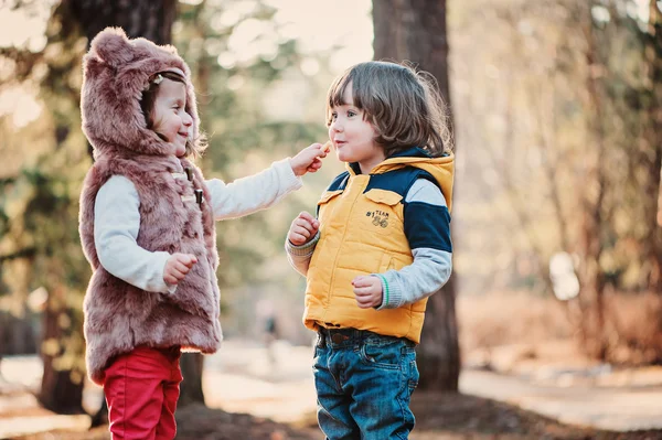 Щаслива дівчинка-малюк дає печиво своєму другу на прогулянці в лісі — стокове фото