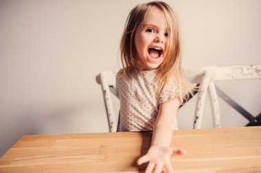 Şirin mutlu yürümeye başlayan çocuk kız evde mutfakta eğleniyor