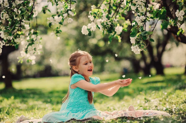 Menina criança feliz jogando no jardim de maçã florescendo primavera — Fotografia de Stock