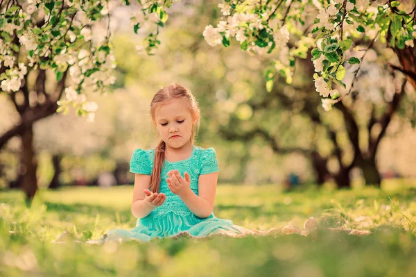 Счастливая девочка играет весной цветущий яблоневый сад — стоковое фото