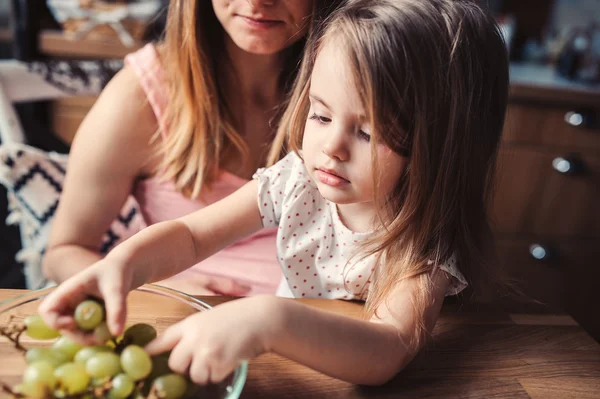 Gelukkig moeder en peuter dochter thuis ontbijten. Gezellige ochtend, levensstijl vastleggen — Stockfoto