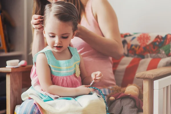 가정에서 그녀의 작은 딸 머리를 솔 질 하는 사랑이 있는 어머니 — 스톡 사진