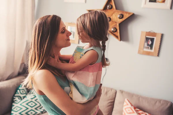 Gelukkig liefhebbende moeder en haar baby dochter met plezier en spelen thuis — Stockfoto