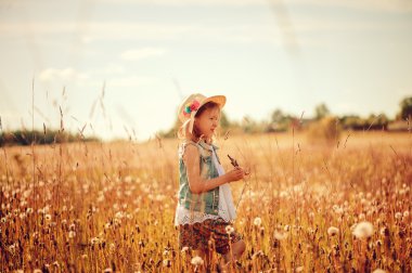 happy child on summer field, spending vacation outdoor, warm rural scene