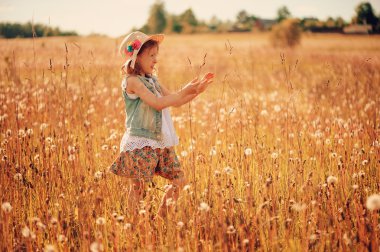 happy child on summer field, spending vacation outdoor, warm rural scene