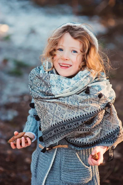 Happy child girl on cozy warm outdoor winter walk in snowy forest — Stockfoto