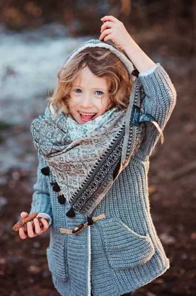 Happy child girl on cozy warm outdoor winter walk in snowy forest — Stockfoto