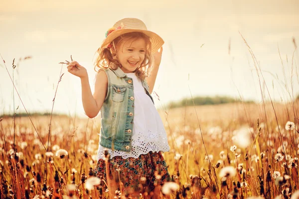 Happy child on summer field, spending vacation outdoor, warm rural scene — Stockfoto